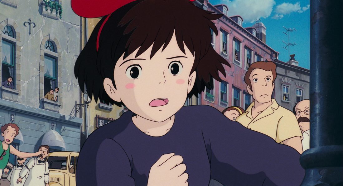 Primer plano de Kiki con el lazo rojo, en una calle de Koriko