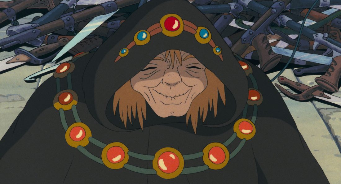 Obaba, encapuchada y con el collar de piedras, con los ojos cerrados