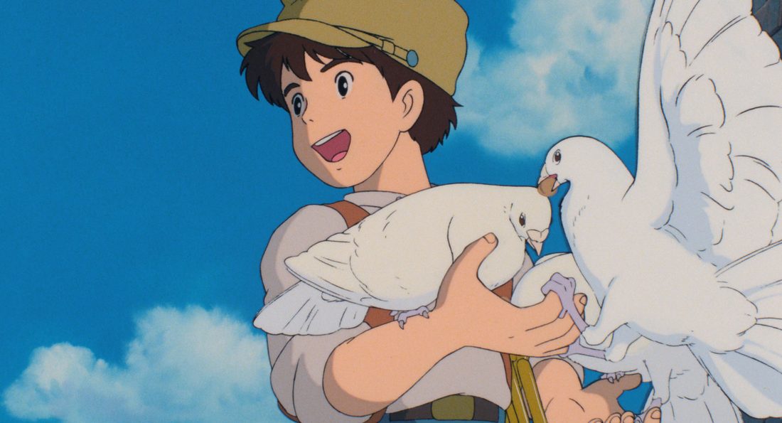 Pazu, con la gorra puesta, sostiene una paloma blanca contra el cielo