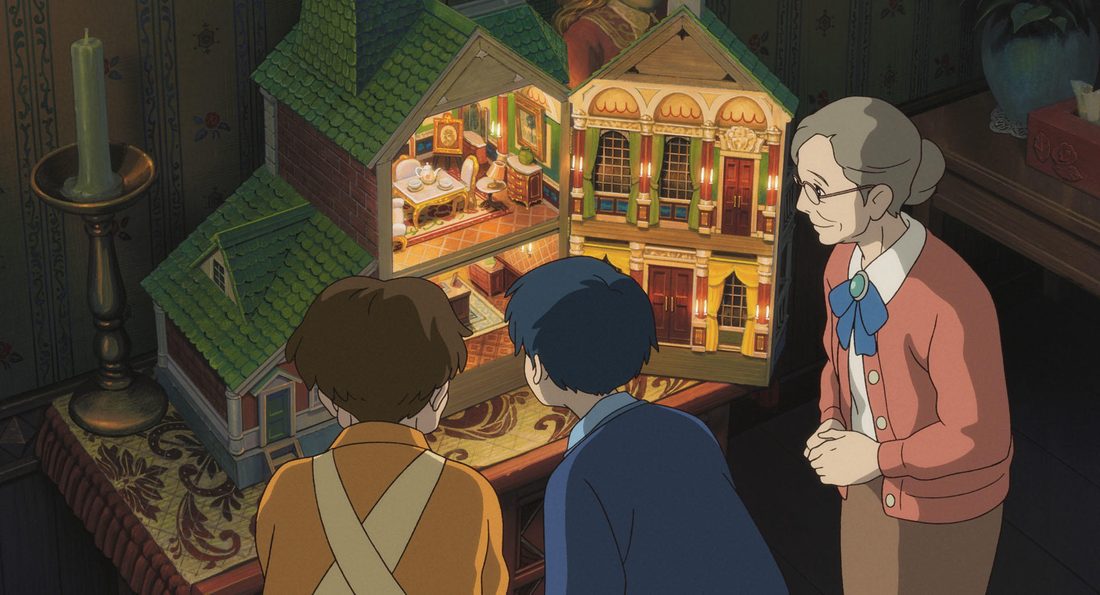 Sadako, de pie junto a la casa de muñecas iluminada