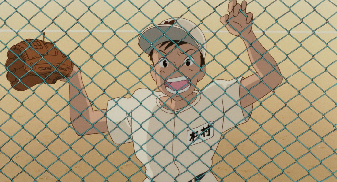 Sugimura, con el uniforme de béisbol, agarrado a la valla metálica