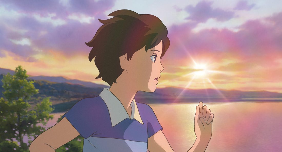 Anna recortada contra el sol que se pone sobre el agua