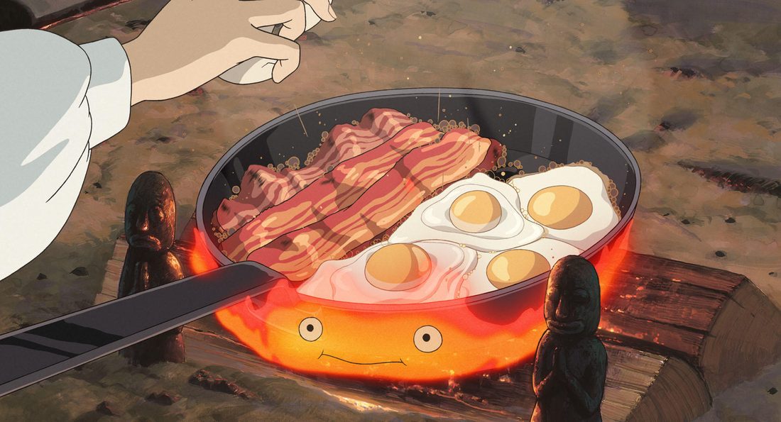 Calcifer aguanta la sartén de huevos con beicon sobre las llamas