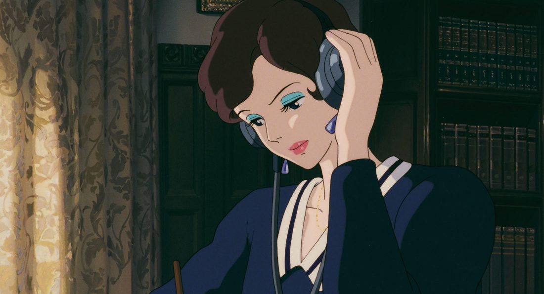 Gina escucha el teléfono en la penumbra del salón