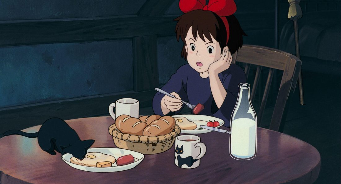 Jiji husmea en la mesa del desayuno, al lado de Kiki