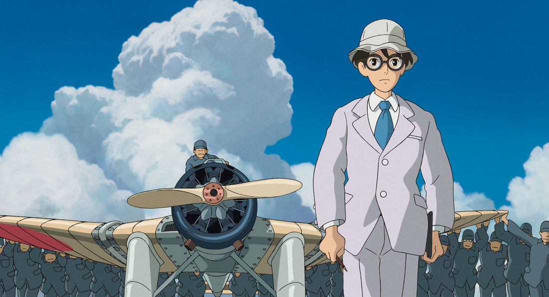 Jirō, de traje blanco, junto a la hélice de su avión