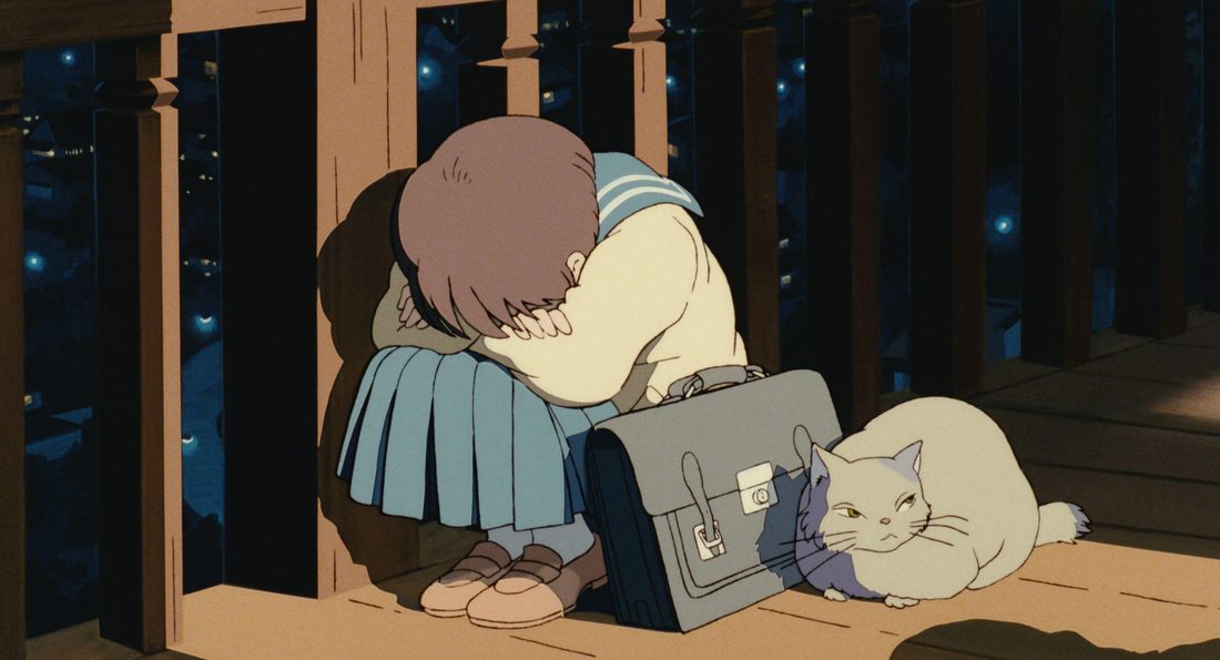 Dormida sobre su cartera, con un gato al lado
