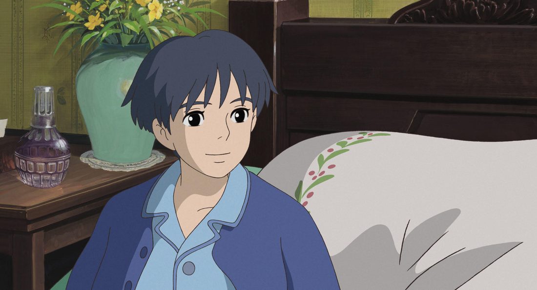 Sho sentado en la cama, con el pijama azul