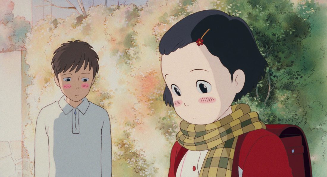 Taeko de niña, con la cartera roja, junto a un compañero