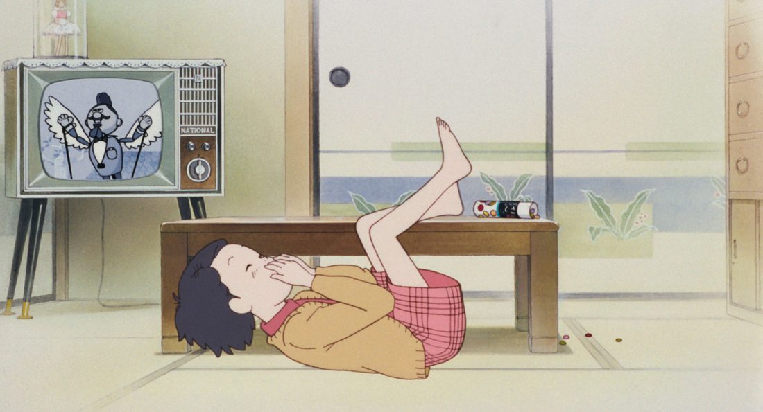 Taeko de niña, tumbada en el suelo delante del televisor