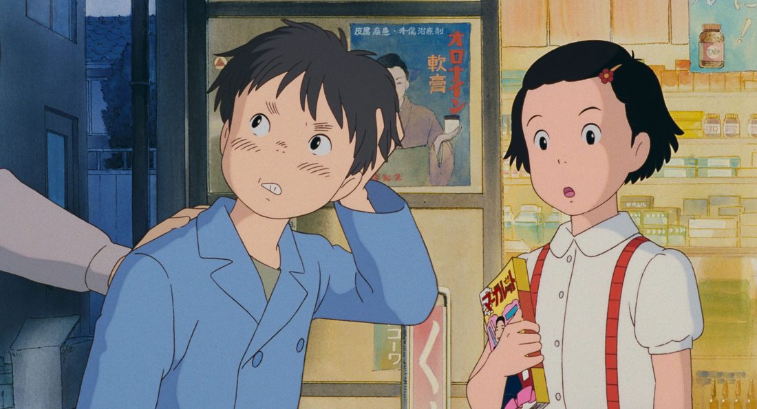 Taeko de niña, con una chuchería en la mano, en la tienda