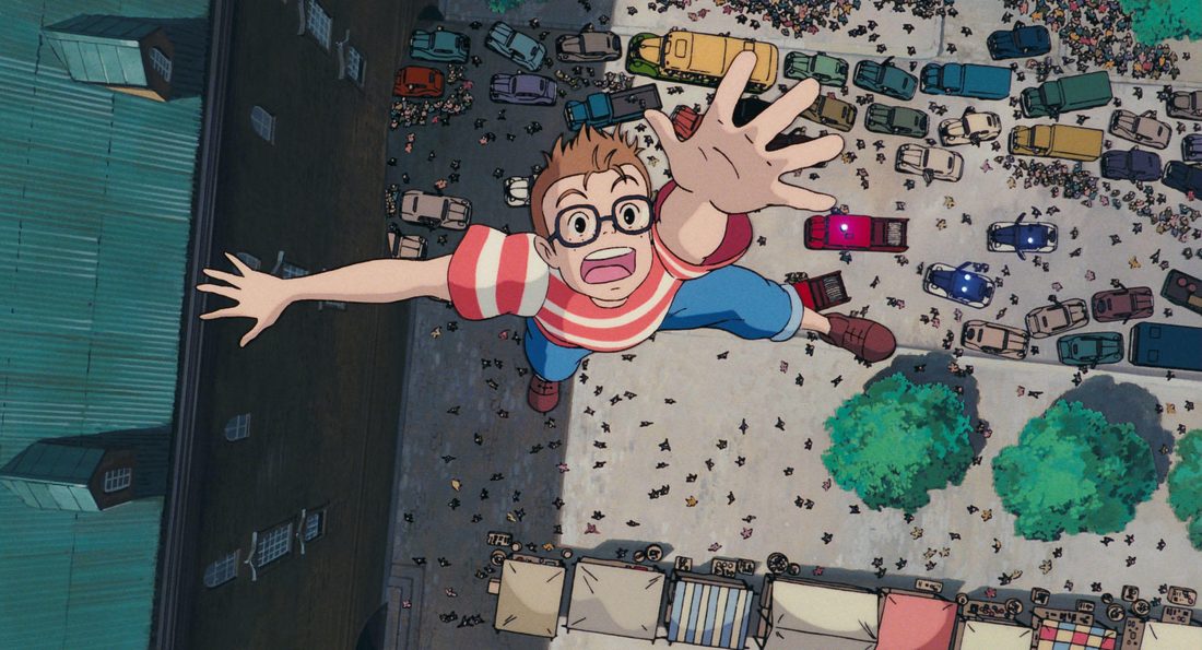 Tombo colgado de la maroma del dirigible sobre la avenida